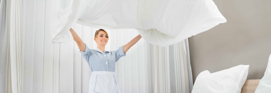 Skyvell woman wearing a white apron and holding a white sheet